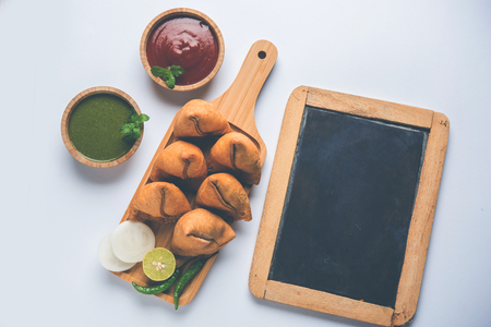 Samosa snack served with tomato ketchup and mint chutneyの写真素材