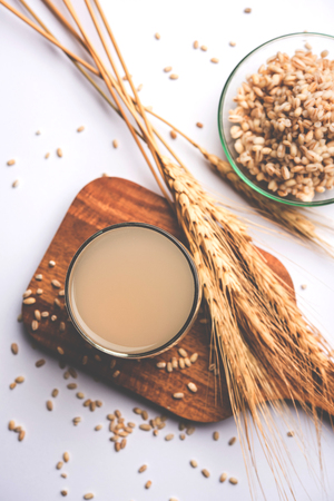 Barley water in glass with raw and cooked pearl barley wheat/seeds. selective focusの写真素材