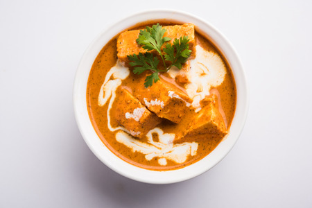 Paneer Butter Masala also known as Panir  makhani or makhanwala. served in a ceramic or terracotta bowl with fresh cream and coriander. Isolated over colourful moody background. selective focusの写真素材