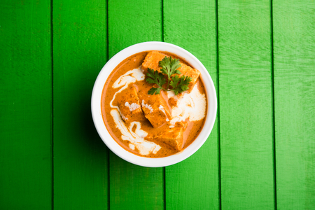 Paneer Butter Masala also known as Panir  makhani or makhanwala. served in a ceramic or terracotta bowl with fresh cream and coriander. Isolated over colourful moody background. selective focusの写真素材