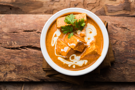 Paneer Butter Masala also known as Panir  makhani or makhanwala. served in a ceramic or terracotta bowl with fresh cream and coriander. Isolated over colourful moody background. selective focusの写真素材