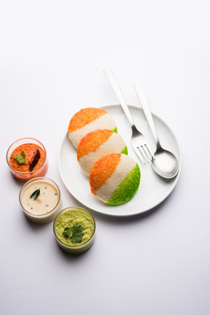 Tiranga Idly or Idli made using Indian National Flag colours like saffron, white and green. Served with colourful chutney. Concept for Happy Independence day greeting cardの写真素材
