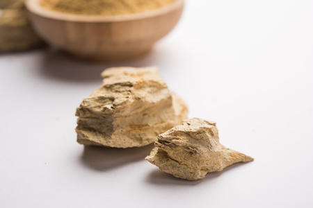 Fuller'S Earth Clay OR Multani mitti in a bowl along with raw stones and mortarの写真素材