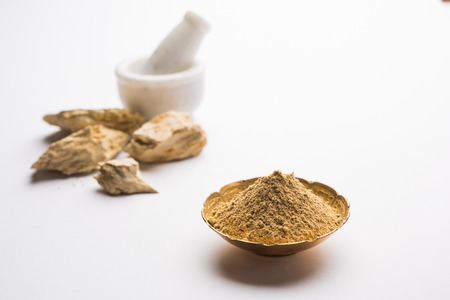 Fuller'S Earth Clay OR Multani mitti in a bowl along with raw stones and mortarの写真素材