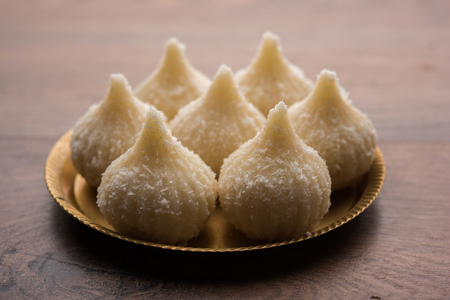 Sweet Modak made using coconut, khoya and sugar. Popular Maharashtrian recipe offered to lord Ganesha in Ganesh Festival. Served in a plate. Selective focusの写真素材