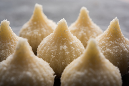 Sweet Modak made using coconut, khoya and sugar. Popular Maharashtrian recipe offered to lord Ganesha in Ganesh Festival. Served in a plate. Selective focusの写真素材