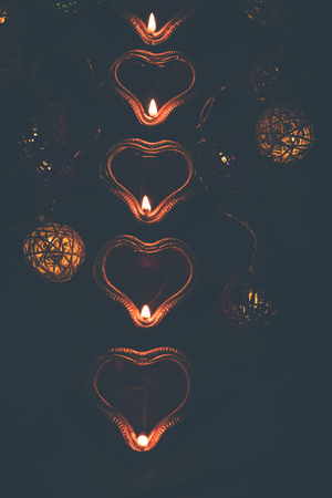 Beautiful diwali diyas at night with flowers, lighting series and gifts, moody backgroundの写真素材