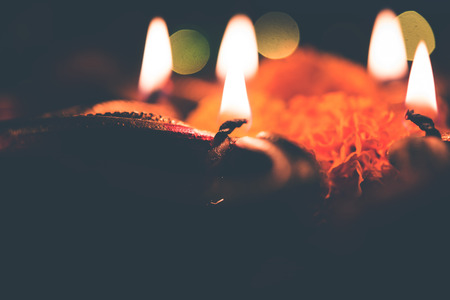 Beautiful diwali diyas at night with flowers, lighting series and gifts, moody backgroundの写真素材