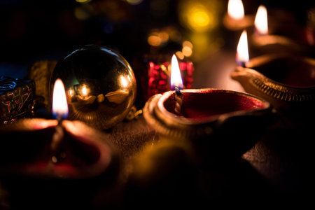 Beautiful diwali diyas at night with flowers, lighting series and gifts, moody backgroundの写真素材