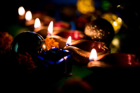 Beautiful diwali diyas at night with flowers, lighting series and gifts, moody background
