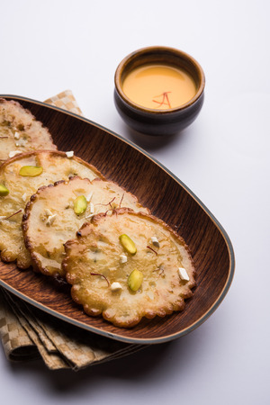 Malpua sweet - Traditional Indian dessert or pancake for festivals, served in plate with rabri/rabdi . selective focusの写真素材