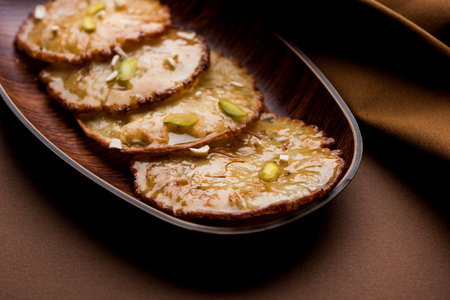 Malpua sweet - Traditional Indian dessert or pancake for festivals, served in plate with rabri/rabdi...