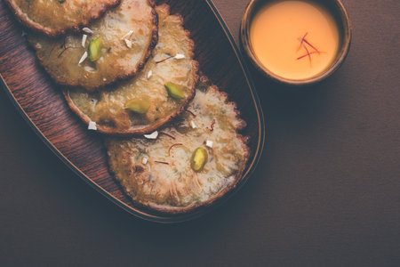 Malpua sweet - Traditional Indian dessert or pancake for festivals, served in plate with rabri/rabdi...