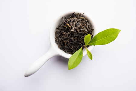 Black Tea Powder or dry dust with or without green leaf and served hot chai in a cupの写真素材