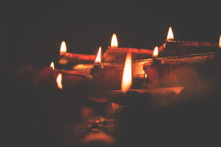 Diwali diya or lighting in the night with gifts, flowers over moody background. Selective focusの写真素材