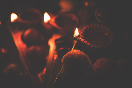 Diwali diya or lighting in the night with gifts, flowers over moody background. Selective focusの写真素材