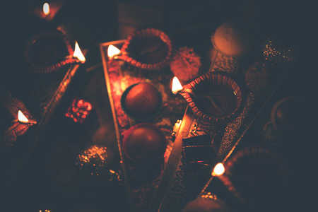 Diwali diya or lighting in the night with gifts, flowers over moody background. Selective focusの写真素材