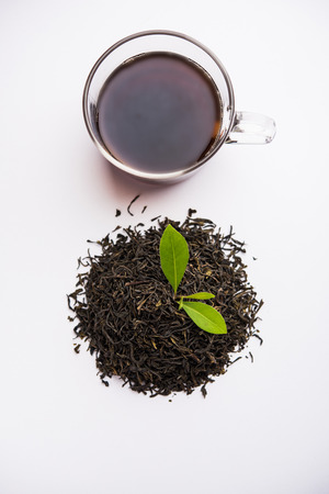 Black Tea Powder or dry dust with or without green leaf and served hot chai in a cupの写真素材