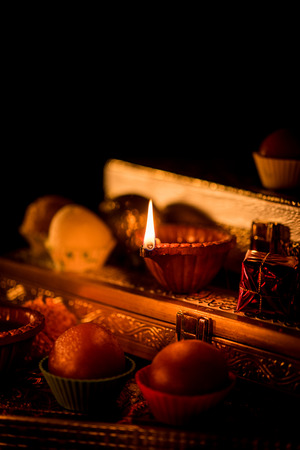 Diwali diya or lighting in the night with gifts, flowers over moody background. Selective focusの写真素材