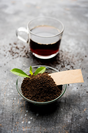 Black Tea Powder or dry dust with or without green leaf and served hot chai in a cupの写真素材