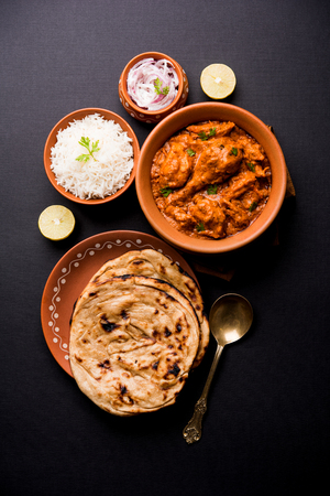 Murgh Makhani / Butter chicken tikka masala served with roti / Paratha and plain rice along with onion salad. selective focusの写真素材