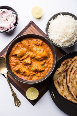 Murgh Makhani / Butter chicken tikka masala served with roti / Paratha and plain rice along with onion salad. selective focusの写真素材