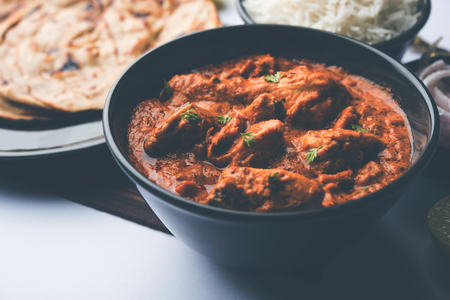 Murgh Makhani / Butter chicken tikka masala served with roti / Paratha and plain rice along with onion salad. selective focusの写真素材