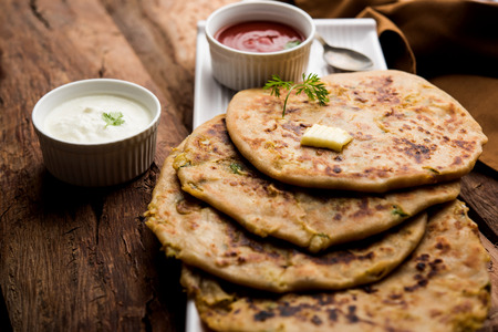 Aloo Paratha / Indian Potato stuffed Flatbread. Served with fresh curd and tomato ketchup. selective focusの写真素材