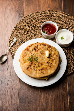 Aloo Paratha / Indian Potato stuffed Flatbread. Served with fresh curd and tomato ketchup. selective focusの写真素材
