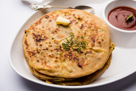 Aloo Paratha / Indian Potato stuffed Flatbread. Served with fresh curd and tomato ketchup. selective focusの写真素材
