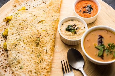 Onion rava masala dosa is a South Indian instant breakfast served with chutney and sambar over moody...