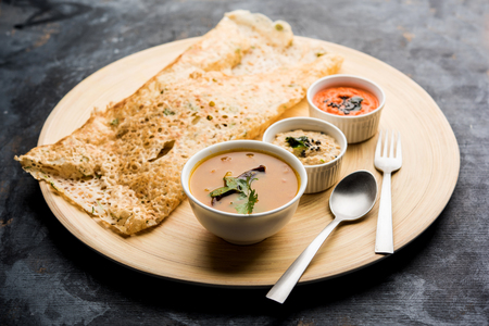 Onion rava masala dosa is a South Indian instant breakfast served with chutney and sambar over moody background. selective focusの写真素材