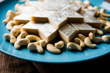 Kaju Katli is a Diamond shape Indian sweet made using cashew sugar and mava, served in a plate or bowl over moody background. selective focusの写真素材