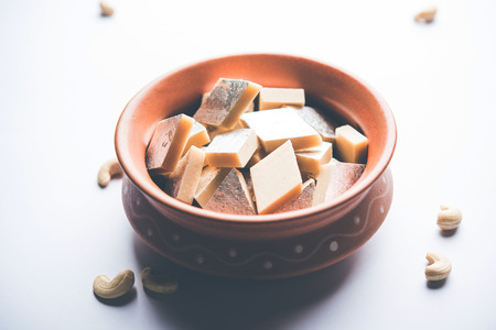 Kaju Katli is a Diamond shape Indian sweet made using cashew sugar and mava, served in a plate or bowl over moody background. selective focusの写真素材