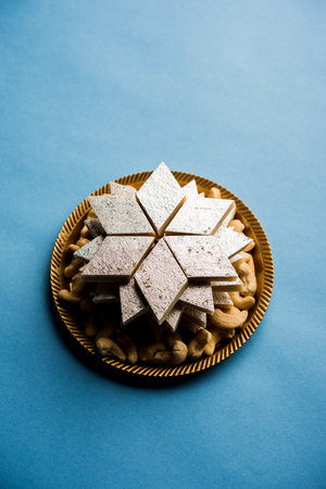 Kaju Katli is a Diamond shape Indian sweet made using cashew sugar and mava, served in a plate or bowl over moody background. selective focusの写真素材