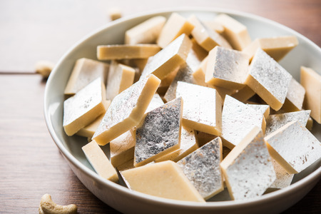 Kaju Katli is a Diamond shape Indian sweet made using cashew sugar and mava, served in a plate or bowl over moody background. selective focusの写真素材