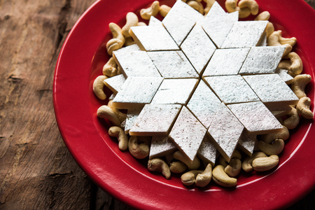 Kaju Katli is a Diamond shape Indian sweet made using cashew sugar and mava, served in a plate or bowl over moody background. selective focusの写真素材