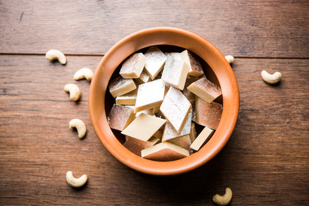 Kaju Katli is a Diamond shape Indian sweet made using cashew sugar and mava, served in a plate or bowl over moody background. selective focusの写真素材