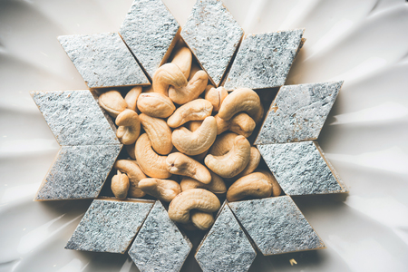 Kaju Katli is a Diamond shape Indian sweet made using cashew sugar and mava, served in a plate or bowl over moody background. selective focusの写真素材