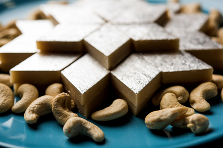 Kaju Katli is a Diamond shape Indian sweet made using cashew sugar and mava, served in a plate or bowl over moody background. selective focusの写真素材