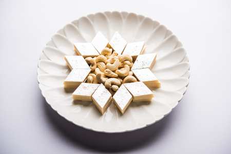 Kaju Katli is a Diamond shape Indian sweet made using cashew sugar and mava, served in a plate or bowl over moody background. selective focusの写真素材