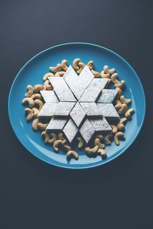 Kaju Katli is a Diamond shape Indian sweet made using cashew sugar and mava, served in a plate or bowl over moody background. selective focusの写真素材