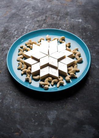 Kaju Katli is a Diamond shape Indian sweet made using cashew sugar and mava, served in a plate or bowl over moody background. selective focusの写真素材