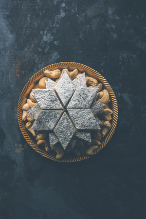 Kaju Katli is a Diamond shape Indian sweet made using cashew sugar and mava, served in a plate or bowl over moody background. selective focusの写真素材