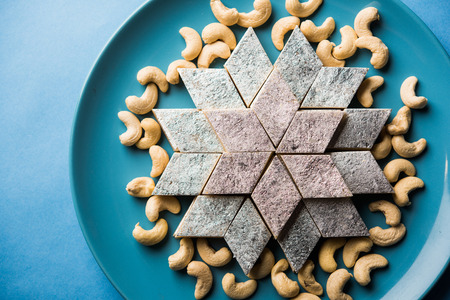 Kaju Katli is a Diamond shape Indian sweet made using cashew sugar and mava, served in a plate or bowl over moody background. selective focusの写真素材