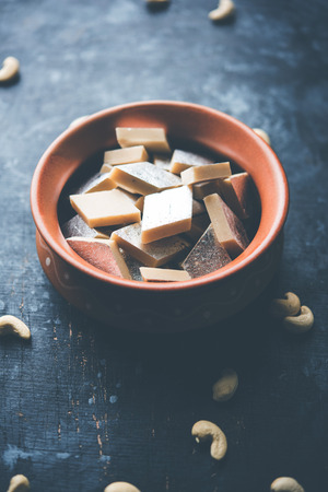 Kaju Katli is a Diamond shape Indian sweet made using cashew sugar and mava, served in a plate or bowl over moody background. selective focusの写真素材