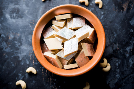 Kaju Katli is a Diamond shape Indian sweet made using cashew sugar and mava, served in a plate or bowl over moody background. selective focusの写真素材