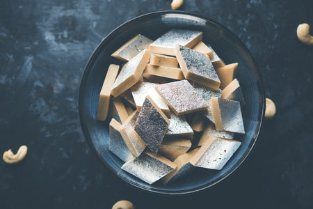 Kaju Katli is a Diamond shape Indian sweet made using cashew sugar and mava, served in a plate or bowl over moody background. selective focusの写真素材