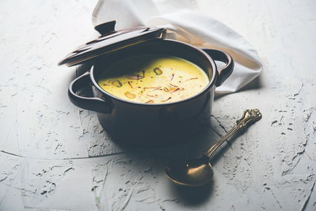 Basundi Or Rabri is an Indian sweet popular in Gujarat and Maharashtra. It is a sweetened condensed milk. Garnished with Dry fruits and Saffron. Served in a bowl over moody background. Selective focusの写真素材