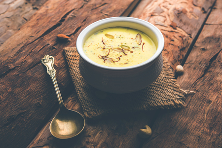 Basundi Or Rabri is an Indian sweet popular in Gujarat and Maharashtra. It is a sweetened condensed milk. Garnished with Dry fruits and Saffron. Served in a bowl over moody background. Selective focusの写真素材